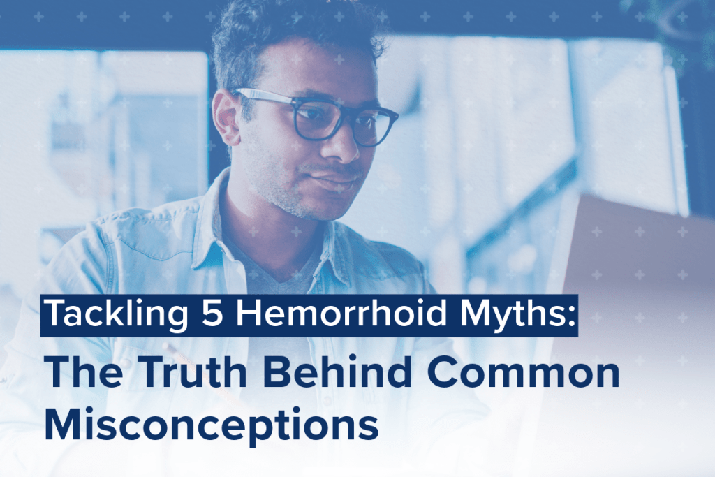 A person wearing glasses works at a computer, with text overlay: Uncovering Hemorrhoid Myths: The Truth Behind Common Misconceptions.