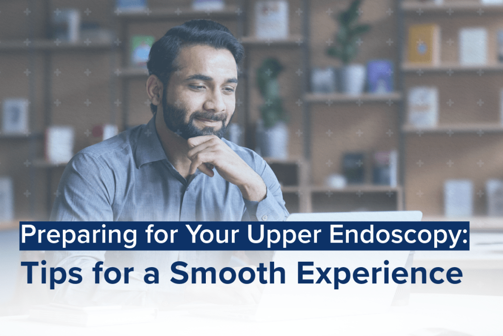 A man with a beard sitting at a desk, smiling while working on a laptop, with a caption overlay that reads "Preparing for Your Upper Endoscopy: Tips for a Smooth Experience."