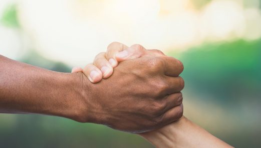 Two people clasp hands firmly in a handshake against a blurred outdoor background, symbolizing trust and reassurance before a colonoscopy. Two people clasp hands firmly in a handshake against a blurred outdoor background, symbolizing trust and reassurance before a colonoscopy.